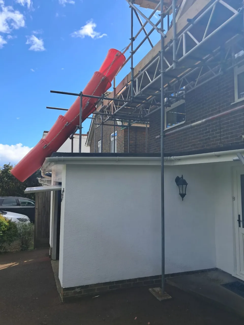 Bridged roofing scaffold above an extension at a Harrogate house, with a rubbish chute running to ground level
